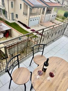 two tables and chairs with wine glasses on a balcony at Suite Altura in Cuneo