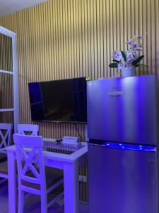 a kitchen with a refrigerator and a table and chairs at MOA Prime Staycation Sea Residences in Manila