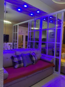 a living room with a purple couch with pillows at MOA Prime Staycation Sea Residences in Manila
