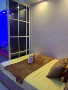 a bedroom with a bed with two pillows and a window at MOA Prime Staycation Sea Residences in Manila
