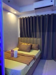a bed in a room with a window with curtains at MOA Prime Staycation Sea Residences in Manila