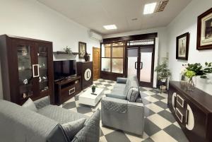a living room with two couches and a tv at Casa Miguelín in Montecorto
