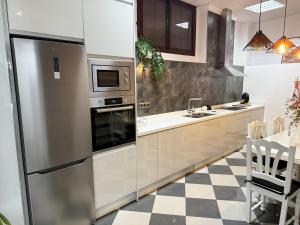 a kitchen with stainless steel appliances and a checkered floor at Casa Miguelín in Montecorto