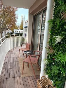 a balcony with two chairs and a table on a building at Escale Cosy à Villeneuve in Villeneuve-la-Garenne