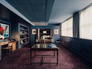 a room with a table and a desk and a window at Aethos Hotel Milan in Milan