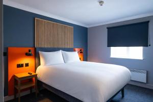 a bedroom with a large white bed and a window at Village Hotel Coventry in Coventry +37 photos