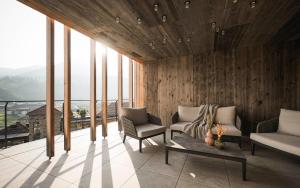 a room with two chairs and a table and windows at Excelsior Dolomites Life Resort in San Vigilio Di Marebbe