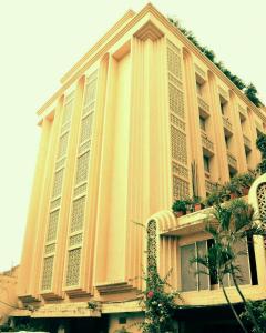 ムンバイにあるHotel Mogul Palace - Near CST Stationの柱と植物が並ぶ大きな建物