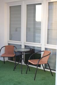 two chairs and a table and two chairs on a balcony at Apartamentos Lumael in Mérida