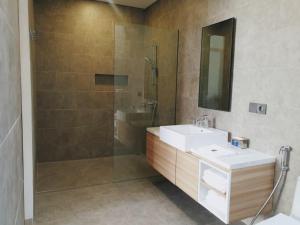 a bathroom with a shower and a sink and a mirror at R7 Cottages Pangandaran in Cikembulan +4 photos