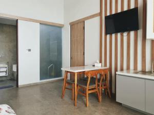 a kitchen with a table and a tv on a wall at R7 Cottages Pangandaran in Cikembulan