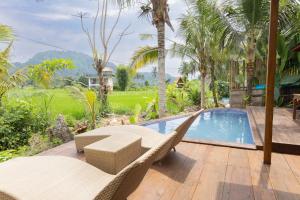 a patio with chairs and a swimming pool at Kelapa Sunrise Villa in Silebeng