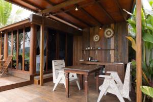 a wooden deck with a wooden table and chairs at Kelapa Sunrise Villa in Silebeng
