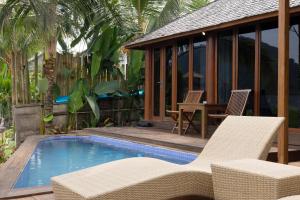 a pool with chairs and a table and a house at Kelapa Sunrise Villa in Silebeng