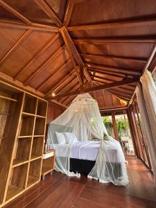 a bed in a room with a net at Kelapa Sunrise Villa in Silebeng