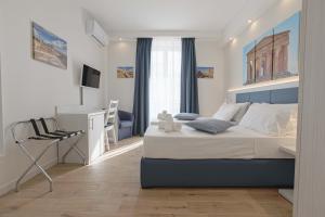 a bedroom with a bed and a desk and a chair at B&B Sikelia Suite in Agrigento