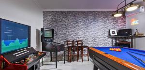 a living room with a pool table and a tv at Renko Royal Villa - Private Infinity Pool & Garden - Athens Riviera in Lagonissi