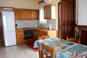a kitchen with a table and a white refrigerator at El Mar in Kómboi