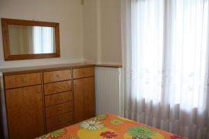 a bedroom with a bed and a dresser and a mirror at El Mar in Kómboi
