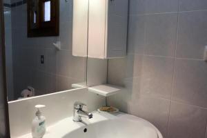 a bathroom with a sink and a mirror at El Mar in Kómboi