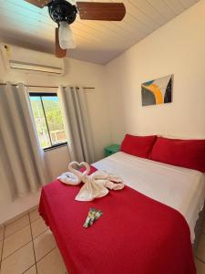 ein Schlafzimmer mit einem rot-weißen Bett und einer roten Decke in der Unterkunft Pousada Luz e Brilho Aluguel Temporada in Búzios