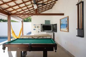 a pool table in a room with a tv at QUINTAL DE BÚZIOS- casa com piscina e 3 suítes completas in Búzios