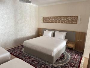 a bedroom with a white bed and a rug at Lazgi Boutique & Spa Hotel in Khiva +64 photos