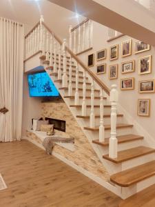 a staircase in a home with a tv on the wall at American Dream Villa in Łazory