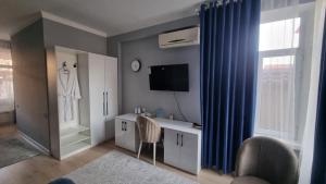 a bathroom with a sink and a mirror and a television at Orom Hotel in Dushanbe