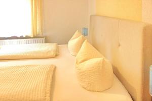 a bedroom with two pillows on a white couch at Pension An der Kamske - DZ 3 in Lübbenau