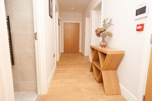 a hallway with a wooden console table in a room at 1 White Rock Heights in Hastings +10 photos