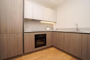 a kitchen with wooden cabinets and a sink and a dishwasher at 1 White Rock Heights in Hastings