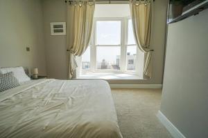 a bedroom with a bed and a large window at 1 White Rock Heights in Hastings