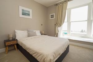 a bedroom with a large bed and a window at 1 White Rock Heights in Hastings