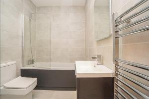 a bathroom with a sink and a toilet and a tub at 1 White Rock Heights in Hastings