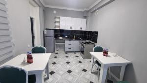 a kitchen with white tables and chairs and appliances at Orom Hotel in Dushanbe