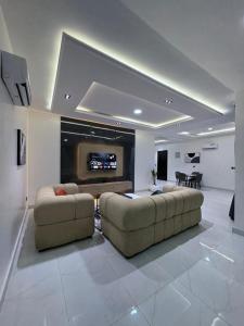a living room with two couches and a flat screen tv at JKB APARTMENt in Lekki