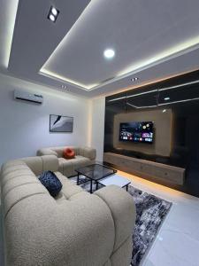 a living room with a couch and a flat screen tv at JKB APARTMENt in Lekki