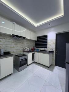 a kitchen with white cabinets and a black door at JKB APARTMENt in Lekki