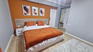 a bedroom with a large bed with an orange blanket at Orom Hotel in Dushanbe +4 photos