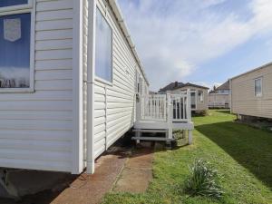 a white house with a porch on the side of it at Caravan CP10 in Prestatyn