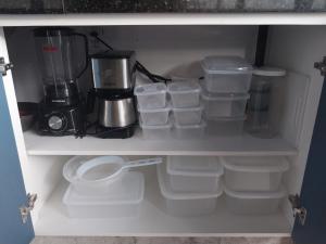a cupboard filled with plastic containers and a blender at QUINTAL DE BÚZIOS- casa com piscina e 3 suítes completas in Búzios +55 photos