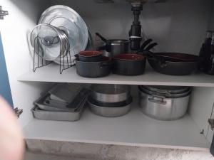 a shelf filled with pots and pans in a kitchen at QUINTAL DE BÚZIOS- casa com piscina e 3 suítes completas in Búzios