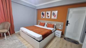 a bedroom with a bed with an orange wall at Orom Hotel in Dushanbe
