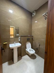 a bathroom with a toilet and a sink at Shree Ram Palace in Chhatikara +18 photos