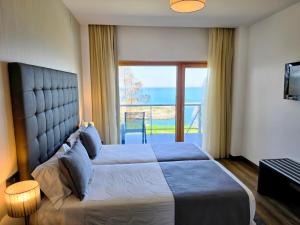 a bedroom with a large bed with a view of the ocean at Hotel Miramar Sul in Nazaré +89 photos