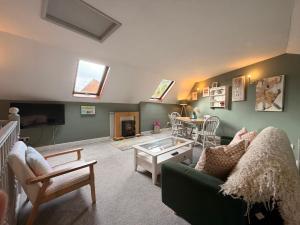 a living room with a green couch and a table at Lorash Cottage, Ashbourne in Ashbourne