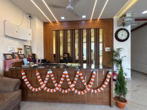 a man sitting at a counter in an office at Shree Ram Palace in Chhatikara