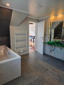 a bathroom with a tub and a sink and a mirror at Loft Linda in Sylt +22 photos