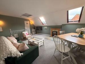 a living room with a green couch and a table at Lorash Cottage, Ashbourne in Ashbourne